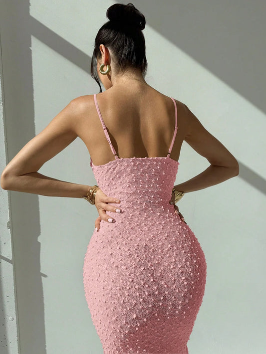 Elegant and romantic long dress for ladies with thin shoulder straps, a cinched waist and a slim figure, made of textured fabric